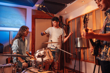 Musician and their producer adjusting microphones before recording in a studio