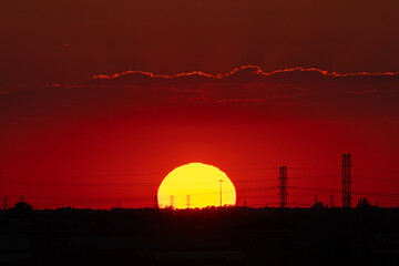 big and large and beautiful sunset in summer behind electrical pole for electricity supply to urban of Houston Texas downtown in USA United State of America