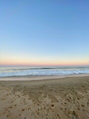 Pastel Dusk Sunset with Waves and Footprints in the Sand