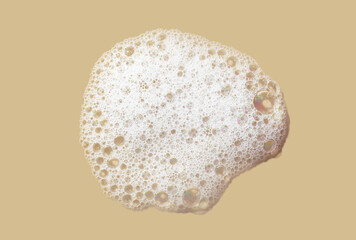 Cosmetic cleansing washing gray foam gel on beige texture