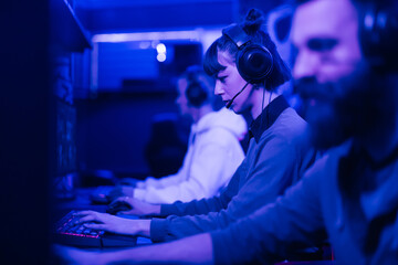 Profile view of a gamer girl playing online game tournament in cybercafe