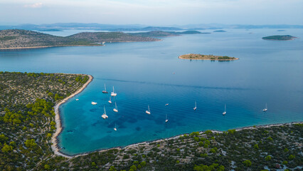 Obraz premium An aerial view of Vela Nozdra, a beautiful bay on the island of Kaprije, Croatia. This secluded spot, nestled between lush greenery and rocky shores, offers crystal-clear waters perfect for swimming