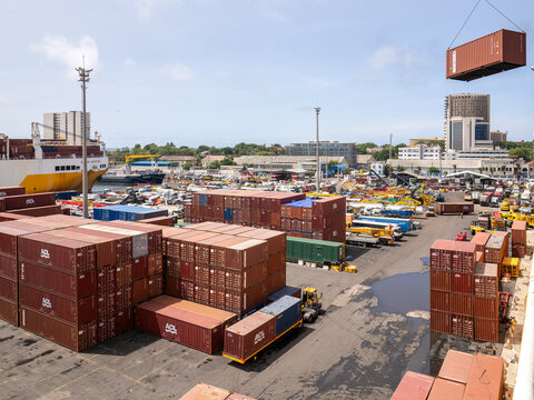 Outdoor view of Dakar industrial harbour, Atlantic ocean, Senegal, West Africa. August, 25, 2024. Ships, boats, cranes, buildings visible. Water at the foreground and clear blue sky in the background