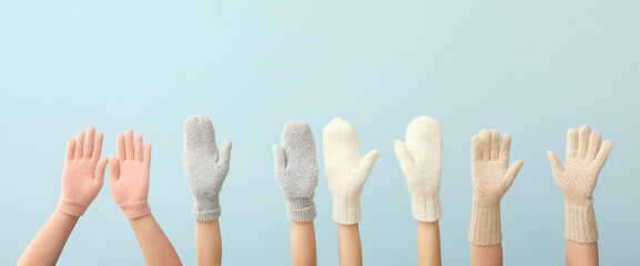 Women in warm gloves on blue background. Winter concept