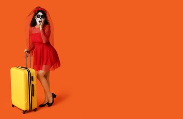Surprised female tourist with suitcase and painted skull on face against orange background with space for text. Mexico's Day of the Dead (El Dia de Muertos)