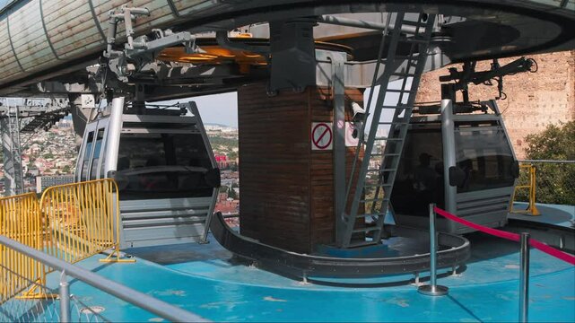 Funicular cab arrives at the designated stop to allow passengers to disembark, while the other funicular cab continues on its journey to explore the city's attractions. Slow motion.