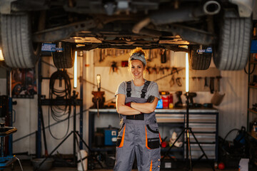 Independent professional female mechanic at workshop with arms crossed