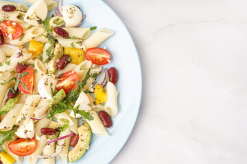 Plate of tasty pasta salad with tomatoes and beans on white background