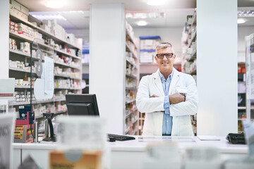 Arms crossed, mature and portrait of man in pharmacy for healthcare, prescription or medical. Dispensary, medicine and wellness with happy pharmacist in drugstore for professional consultation