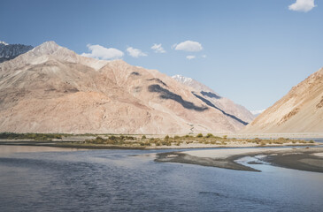 A panorama of the mountain landscape of the Wakhan Corridor and the Panj River in the valley with...