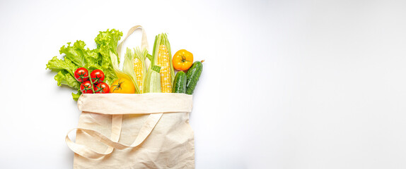 Vegetarian grocery shopping. Different fresh vegetables in a textile shopper bag on white background, healthy vegan food from supermarket or delivery concept, space for text.