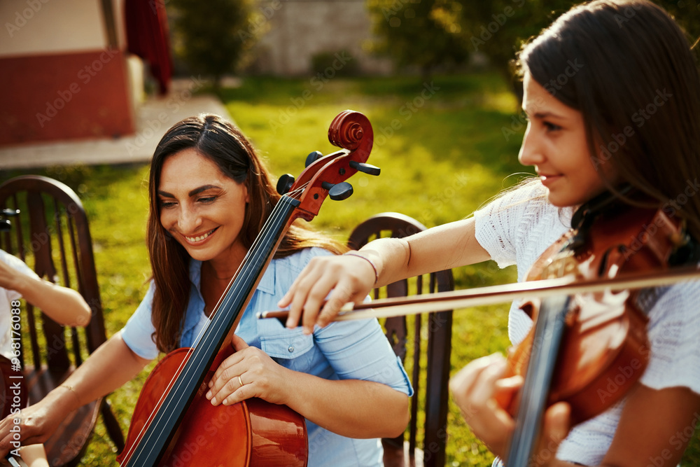 Wall mural Outdoor, band and women with violin, music and creativity with classical music, instrument and nature. People, woods and friends with event for earth day, group and environment with support or talent