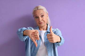 Mature woman showing like and dislike on lilac background