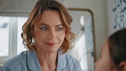 Obraz premium Closeup beautiful mother listening daughter at house. Positive woman talking