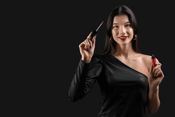 Beautiful young woman with red lipstick on black background