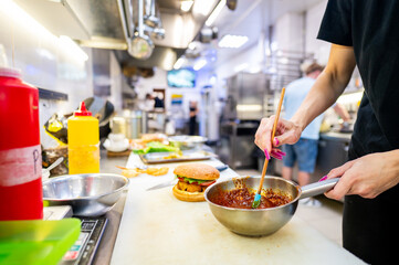 A person preparing food in a kitchen, focusing on hands mixing ingredients in a bowl. Ideal for culinary themes, cooking tutorials, and food blogs. Clean, bright setting with natural light.