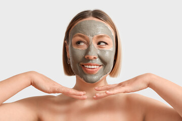 Mature woman with clay mask on light background, closeup