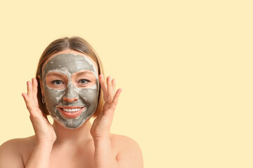 Beautiful mature woman with clay mask on color background
