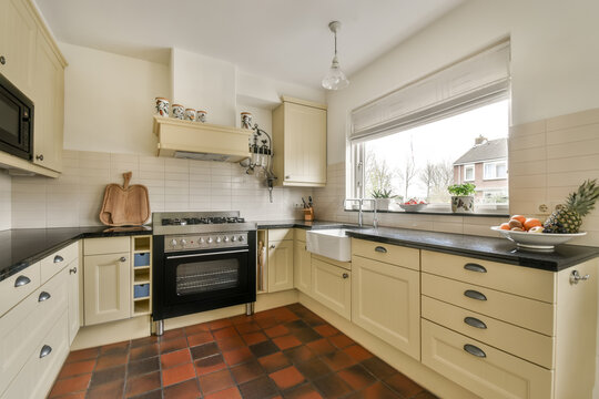 Bright and cozy modern kitchen interior with terracotta tiles