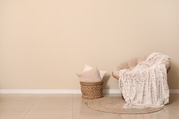 Interior of living room with armchair, cushions and plaid