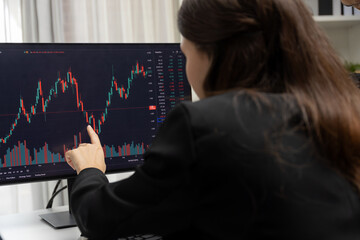 Two business traders discussing on dynamic stock market in currency rate investment trading on two pc screens with compare real time graph on risk or profit point of data at modern office. Postulate.
