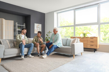 Teenage boy with his dad and grandfather talking at home