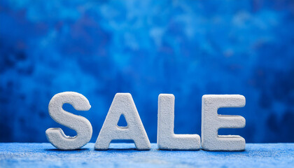 Stone text 'SALE' against blue textured backdrop. Shopping and black friday concept. Grunge wall.