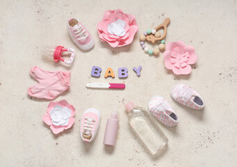 Frame made of clothes, toys, pregnancy test and word BABY on grunge white background