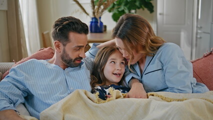 Obraz premium Little girl communicating parents relaxing sofa closeup. Couple kid watching tv