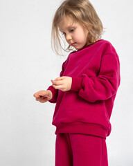 Portrait of cheerful playing girl. Child with smiles and funny emotions on light background. Vertical photo