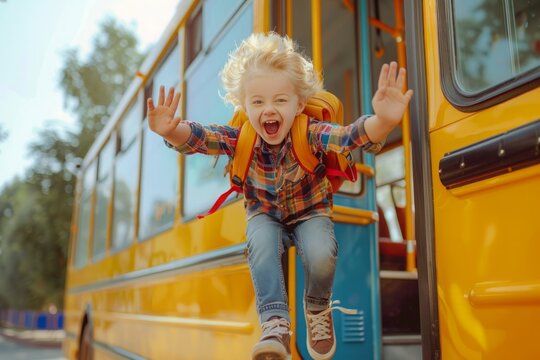 Emotional boy student kid with funny face expression jumping near yellow bus on 1 September day. Education and back to school concept. Child pupil ready to learn and study
