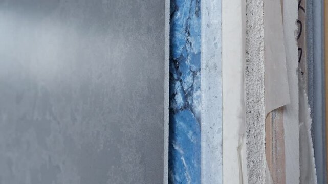 Colorful quartz and porcelain tile stone slab are standing in the factory warehouse. Kitchens and bathrooms countertop selection. Granite slabs are prepared for sale in store yard