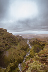 Stunning mountains with cascading waterfalls flowing through the lush Múlagljúfur Canyon in Iceland's rugged landscape