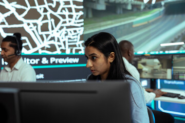 Indian employee following delivery trucks in traffic via mobile map with gps tracking, monitoring location and destination to ensure parcel shipment. Woman uses public surveillance cameras.