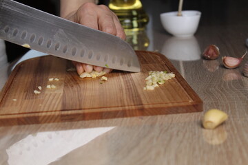 Small chopped garlic on a cutting board close-up of a black foreshortening. The Process of Slicing...