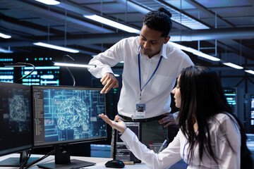 Team of data researchers using AI tech to do checkup in server room providing storage. Teamworking colleagues in data center using PC to enable artificial intelligence to process datasets for training