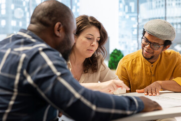 Corporate clients engage in a strategic planning session with a real estate agent, reviewing...