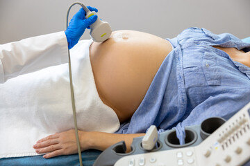 Pregnant woman lying on a couch in clinic while ultrasonography