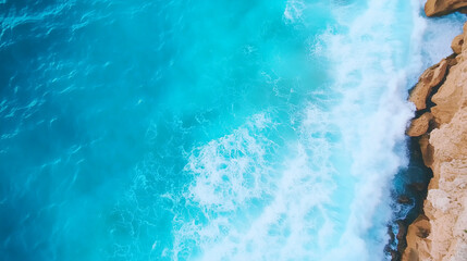Aerial shot of waves crashing against a rocky coastline, vibrant blue waters and white sea foam, dramatic ocean scene, power of nature