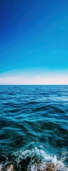 Obraz premium A serene view of the calm ocean under a clear blue sky, perfect for relaxation and escape into nature's beauty.