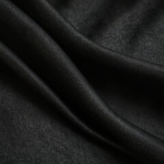 Fototapeta premium Close-up of black fabric with smooth, flowing texture and folds.