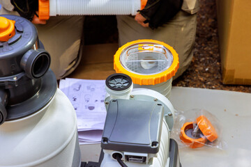Maintenance worker assembles sand filter system tank cleaning equipment for swimming pool