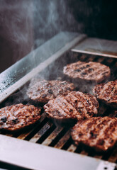 Grilling meat patties for classic burger in a cafe of a restaurant.