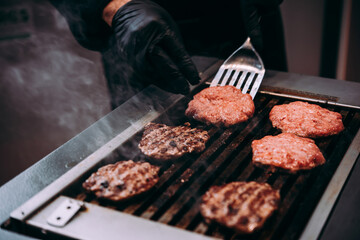 Grilling meat patties for classic burger in a cafe of a restaurant.