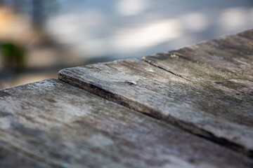 Wooden table in the park, selective focus, vintage tone. Wooden plank close up photo. Wooden texture.
