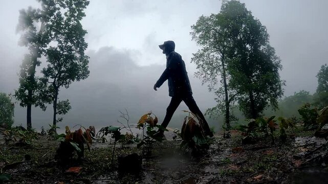 silhouette of a person walking on mountains  meanwhile raining.