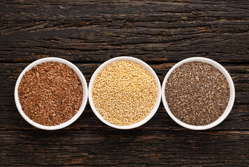 Flax, quinoa and chia seeds in three bowls - Chenopodium quinoa, Salvia hispanica and Linum usitatissimum.