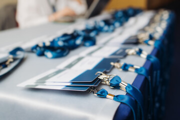 Process of checking in on conference congress forum event, registration desk table, visitors and attendees receiving lanyard with name badge and entry wristband bracelet and register electronic ticket