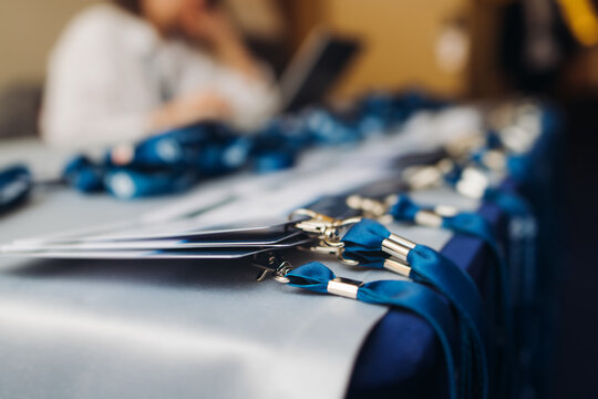 Process of checking in on conference congress forum event, registration desk table, visitors and attendees receiving lanyard with name badge and entry wristband bracelet and register electronic ticket