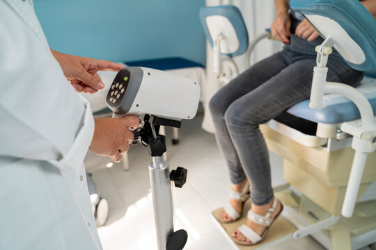 Woman at gynecologist preparing for colposcopy scan, sitting in the chair and taking pants off 